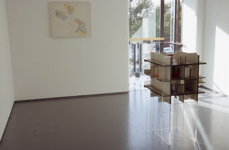 A small architerual model of a block of flats sits in DCA Galleries. On the walls, there is an architectural drawing.