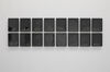 A photograph of an artwork displayed as.a grid of black rectangles.