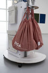 Pink bags featuring the DCA logo hang on a gallery stand 