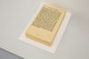 Photo of a book with no cover on a small white shelf protruding from a white wall. The book is 'The Left Hand of Darkness', the pages are yellowed with age, and the text is black.