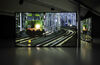 A photograph of a two channel film. The image shows a train on a track. The films reflects off the gallery floor.