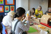 Group of people sitting around a table making paper flowers